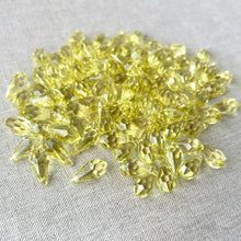 Load image into Gallery viewer, 15mm Jonquil CRYSTALLIZED™ Teardrop Drop Crystals in Jonquil Yellow, top drilled and faceted, displayed in a package of 97 on a neutral fabric background.