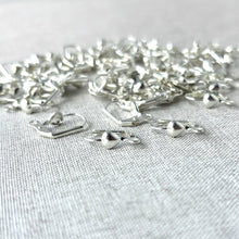 Load image into Gallery viewer, Heart Leverback Earwires - Silver Plated 18mm - Pack of 78 Earwires scattered on a light fabric background, showcasing their smooth silver finish and heart-shaped clasps for jewelry making.