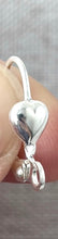 Load image into Gallery viewer, Close-up of a silver-plated heart-shaped leverback earring hook, part of a Heart Leverback Earwires - Silver Plated 18mm - Pack of 78 Earwires, held between fingers.