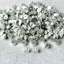 Load image into Gallery viewer, Close-up image of small silver spacer beads with a swirl drum design, showing detailed diamond cut surfaces, labeled Silver Diamond Cut Swirl Drum Beads - 6x4mm - Pkg of 224 - Spacer Beads Metal Beads.