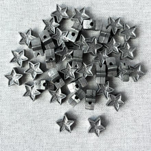 Load image into Gallery viewer, Pewter Stars - 13mm Silver Pewter Stars Beads - Package of 40 beads arranged on a white fabric background, showcasing their star shape and metallic silver finish.