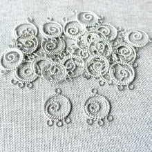Load image into Gallery viewer, Twisted Circle Spiral Chandelier Drop - 13mm Round 3 Loops - Sterling Silver - Package of 24 small, intricately twisted silver spiral connectors for jewelry making on textured fabric background.