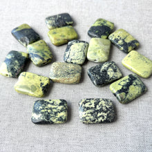 Load image into Gallery viewer, Yellow "turquoise" (natural), 25x18x7mm flat rectangle, B/C grade. Sold per 16-inch strand 16 beads scattered on a light fabric surface showing yellow-green and black variegated patterns.