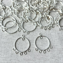 Load image into Gallery viewer, SS Circle Chandelier Drop - 19mm Round 6 Loops - Sterling Silver - Package of 22, featuring small silver chandelier drop connectors arranged on a fabric surface for jewelry making.