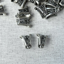 Load image into Gallery viewer, Sterling Silver Open Filigree Bail - 13mm x 11mm - Pack of 20 displayed on a textured fabric background, showcasing intricate open filigree details for jewelry making.