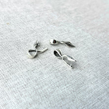 Load image into Gallery viewer, Three small silver plated leaf prong bails designed for jewelry making, styled with delicate leaf details, shown on a textured light fabric background, Leaf Prong Bail - Silver Plated - Pack of 3.