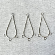 Load image into Gallery viewer, Three silver plated twisted wire teardrop shaped chandelier drops each with three loops arranged on a light fabric background, Twisted Teardrop Chandelier Drop - 36mm Teardrop 3 Loops - Silver Plated - Package of 3.